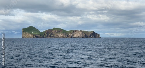 Ellidaey island with the famous hunting lodge on the green hillside, Westman Islands, South Iceland