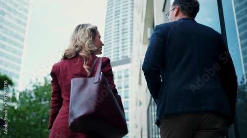 Business colleagues talking outside modern office building.