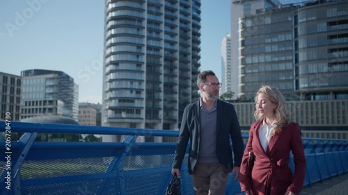 Business colleagues talking outside modern office building.