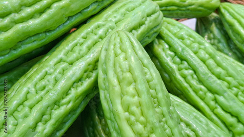 Fotografía Fresh organic bitter melon gourds with textured bumpy skin stacked together at a