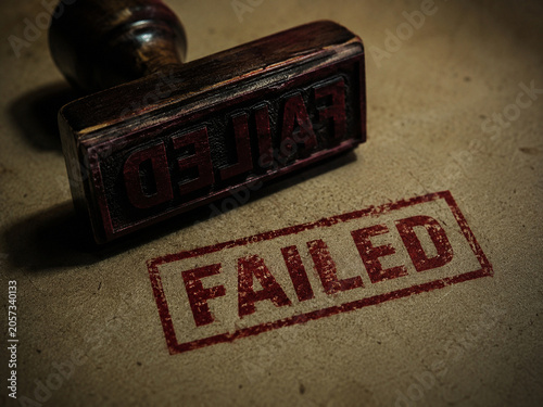 Failed red ink stamp on textured paper symbolizing consequences and accountability and conveying frustration and urgency in corporate review setting