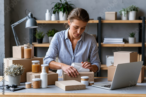 Small business owner packaging products for online orders, modern workspace.
