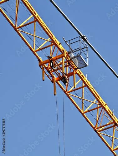 Detail of yellow construction crane jib with trolley and pulleys