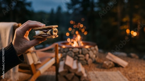 Close Up of Hand Holding a Deliciously Toasted Smores Snack by a Warm Outdoor Campfire Gathering