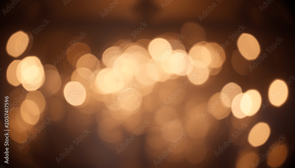 Fototapeta premium Lights shimmer in a soft golden blur against a dark void, creating an atmospheric and warm background perfect for festive holiday designs or romantic emotional storytelling in visual media.