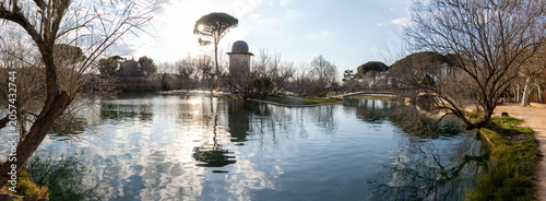 Photography Panoramic view of the thermal lake of Alhama de Aragón, Zaragoza, Spain, with calm waters reflecting the surrounding trees and landscape in a serene natural setting