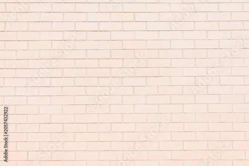Creamy peach painted outdoor brick wall texture. Light orange pastel color exterior brickwork. High key abstract grunge background