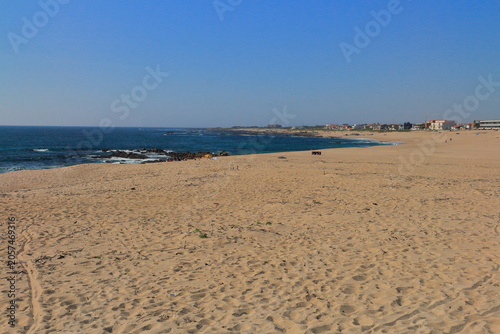 Fotografie A beach with a body of water in the background