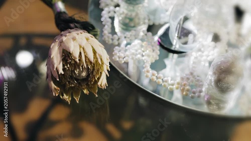 The flower lies on a tray on the table, decorating the space