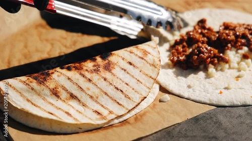 The cook prepares the treat by wrapping the filling in a flatbread. Close-up shooting