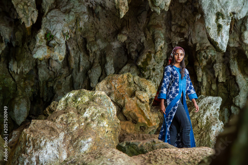 Indonesian Woman Exploring Limestone Cave in Traditional Textile