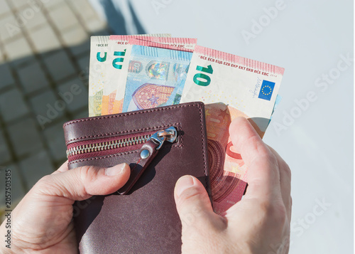 Slika na platnu Leather wallet and euro banknotes in a woman's hands, selective focus