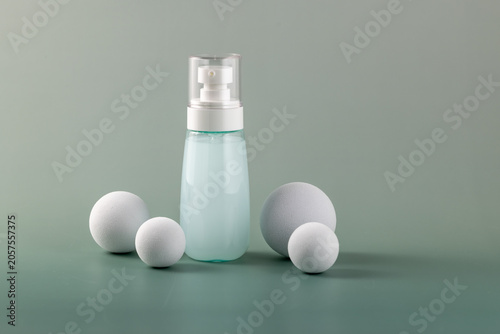 Mockup of a cosmetic bottle on a gradient background next to white balls