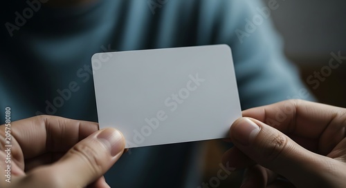 Person holding a blank white card in their hands up close