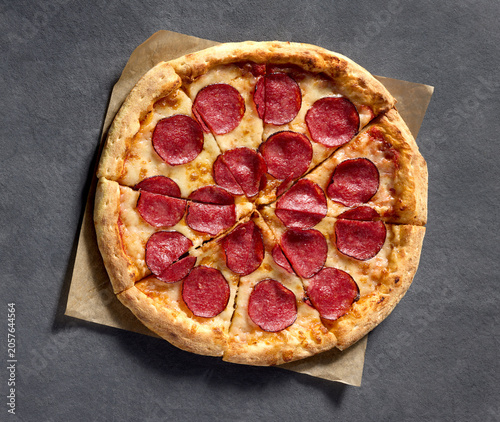 Freshly Baked Sliced Pepperoni Salami Pizza on Dark Gray Background. Top View