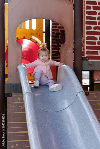 Little Girl Playing on Playground Slide During Outdoor Activity