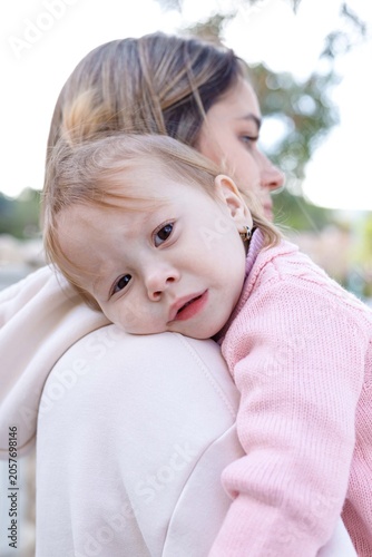 Mother hugs her little daughter during family walk and outdoor recreation.