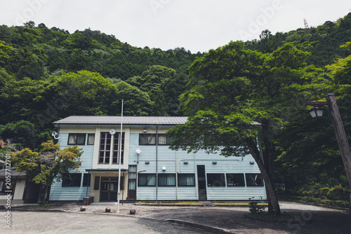 田舎の山間部に建つレトロな木造校舎の外観,
