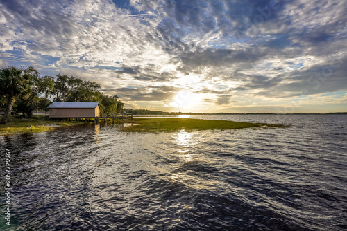 Billede på lærred A glowing sunset stretches across Lake Minneola in Florida, with rippling water,