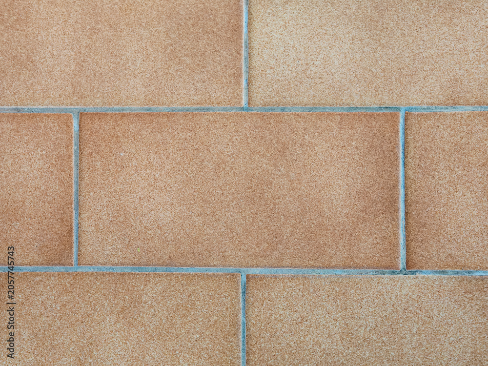 Fototapeta premium Full-frame flat lay of an architectural background featuring orange terracotta brick tiles arranged in a clean geometric running bond pattern with concrete grout lines.