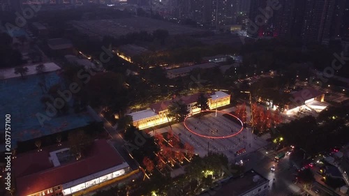 Aerial night view of illuminated urban plaza and surrounding buildings