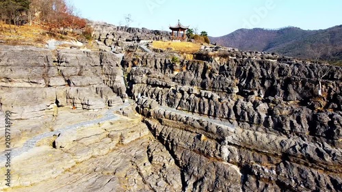 Rocky canyon landscape with stone pathway and traditional pavilion