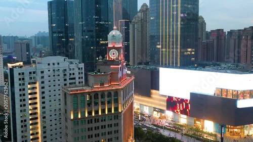 Illuminated Clock Tower and Modern City Skyline at Dusk
