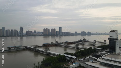 Urban skyline and ferry docks along a wide river at dusk