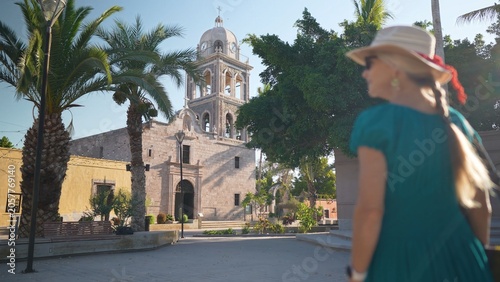Fotografie A senior woman smiles as she explores Loreto Mission church in Loreto, Baja California Sur