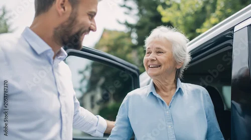 Obraz  z motywem Younger man helping smiling elderly woman out of car, showing care and generations connecting
