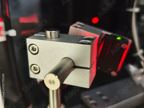 Industrial metal machine component with red light in dark laboratory