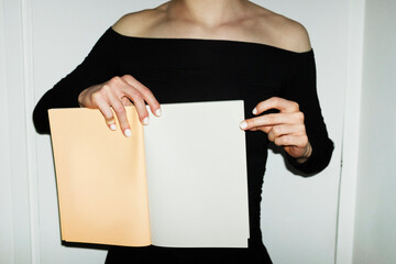 Person holding colourful mockup paper book with empty space for text