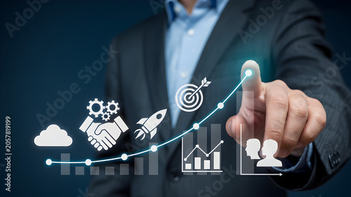 Businessman pointing to growing graph with various business icons