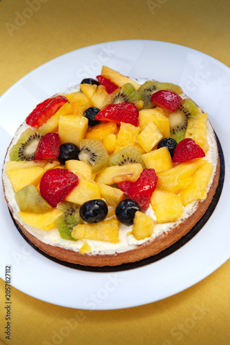 Pineaplle,  strawberries, kiwi and cream on a cake