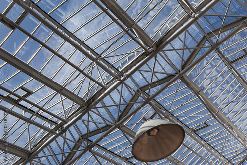 Beams of a glass roof and blue sky in the background