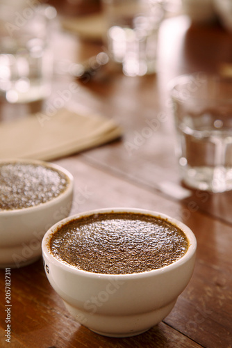 coffee cups prepared for the Q grader professional cupping session to evaluate aroma and flavor. Specialty coffee tasting setup in a cafe or roastery.