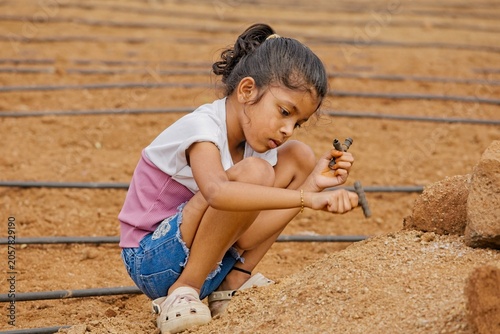 Child working in a field with tools during daytime