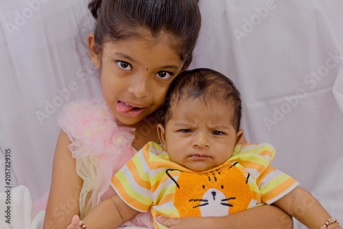 Happy siblings enjoying time together in bright clothing at home