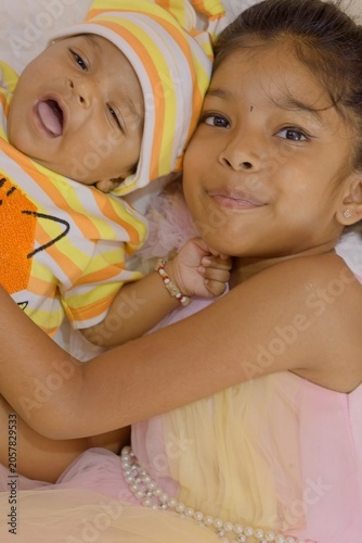 Happy moments with baby and little girl in colorful outfits