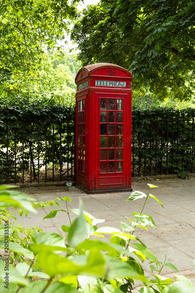 Obraz premium Red telephone box surrounded by trees in London park