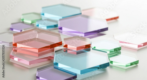 Abstract composition of colorful translucent hexagonal glass tiles on a white surface