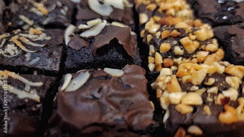 Assortment of chocolate brownies with various toppings nuts, chocolate chips and almond slices