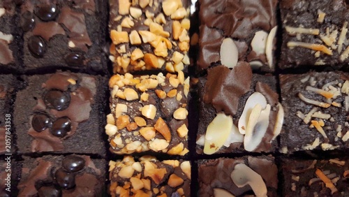 Assortment of chocolate brownies with various toppings nuts, chocolate chips and almond slices
