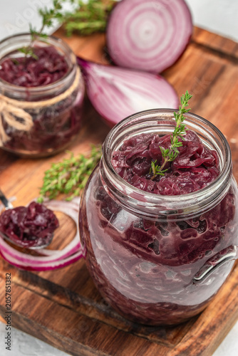 Konstfotografi Homemade red onion marmalade in glass jars with fresh onions and thyme
