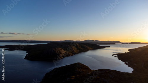 drone shot of midnight sun over Bokfjord near Ropelv in South Varanger, Northern Norway