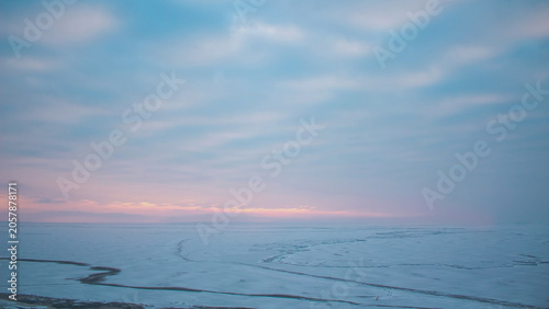 Foto Serene snowy landscape under soft pastel twilight sky with clouds and frozen sea