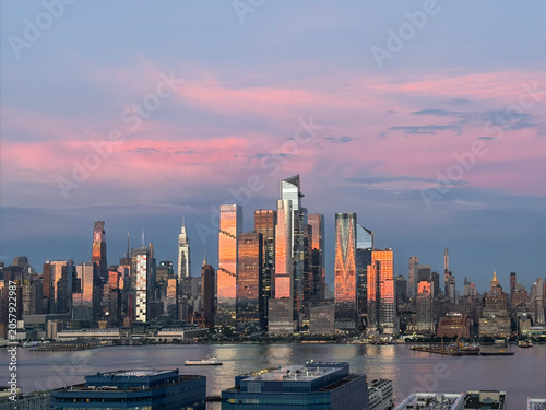 Panoramic Manhattan skyline at sunset with Hudson Yards towers reflecting over Hudson River