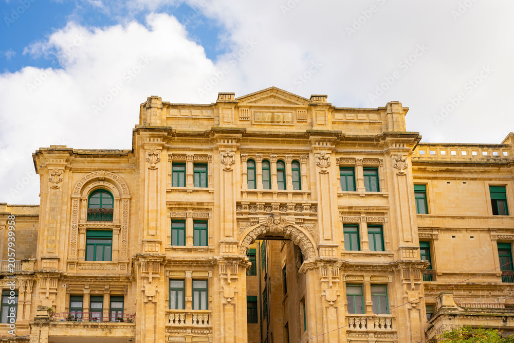 Fototapeta premium This scene depicts Balluta Bay in St. Julian's, Malta, featuring a beach promenade.The large Neo-Gothic building is the Carmelite Church (Parish Church of Our Lady of Mount Carmel).The bay is a popula