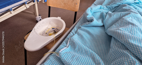 Canvastavla a vessel with a macha and a tube at the patient's bedside in a hospital ward