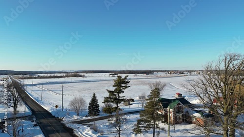 Aerial shot over Caledon, Ontario, Canada on a cold winter afternoon after a heavy snowfall on March 4, 2023. Lifting up, looking south over the Inglewood area overlooking farms and agricultural land.